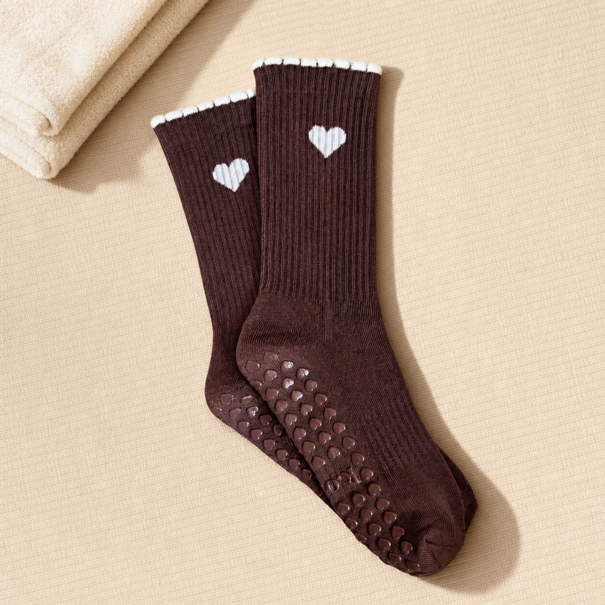 Chocolate Heart brown Pilates grip socks styled on a beige mat – KORRHAUS